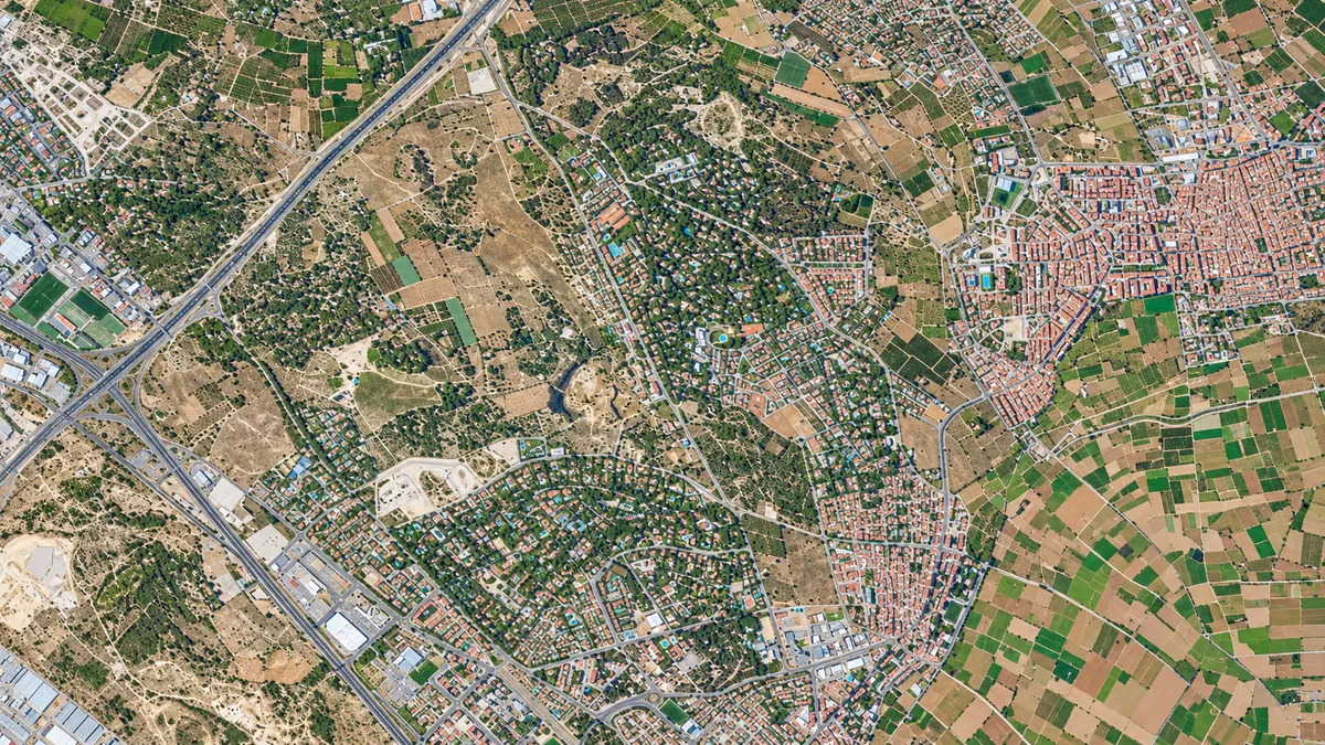 Vista aérea de áreas residenciales, carreteras y parcelas agrícolas en el entorno de Godella