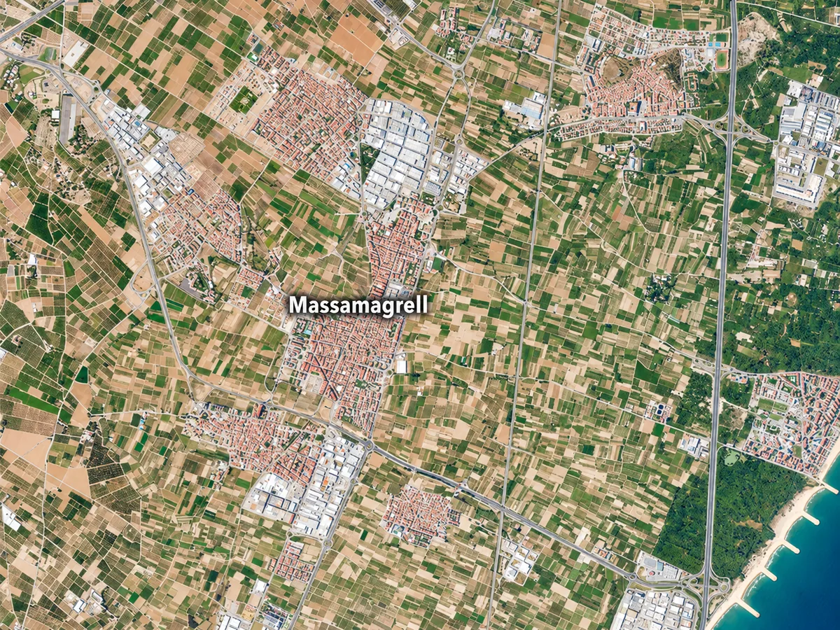 Vista aérea de núcleos urbanos, campos, naves, carreteras y costa, con el rótulo Massamagrell