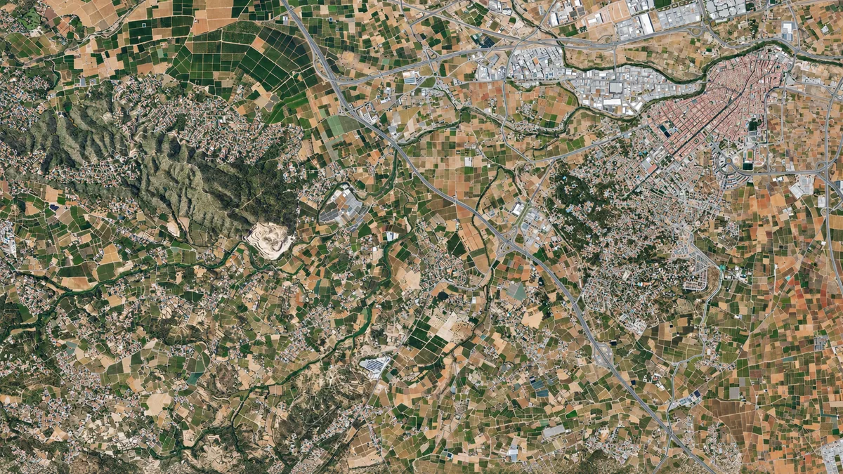 Vista aérea de Torrent con núcleo urbano, áreas residenciales, campos, naves industriales y carreteras